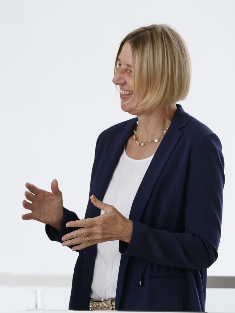Evelyn Wolf im Gespräch, lachend, offene Hände